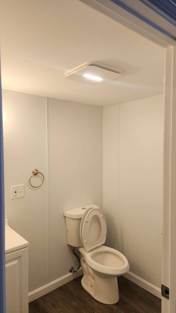 Finished basement bathroom with exhaust fan light over the toilet