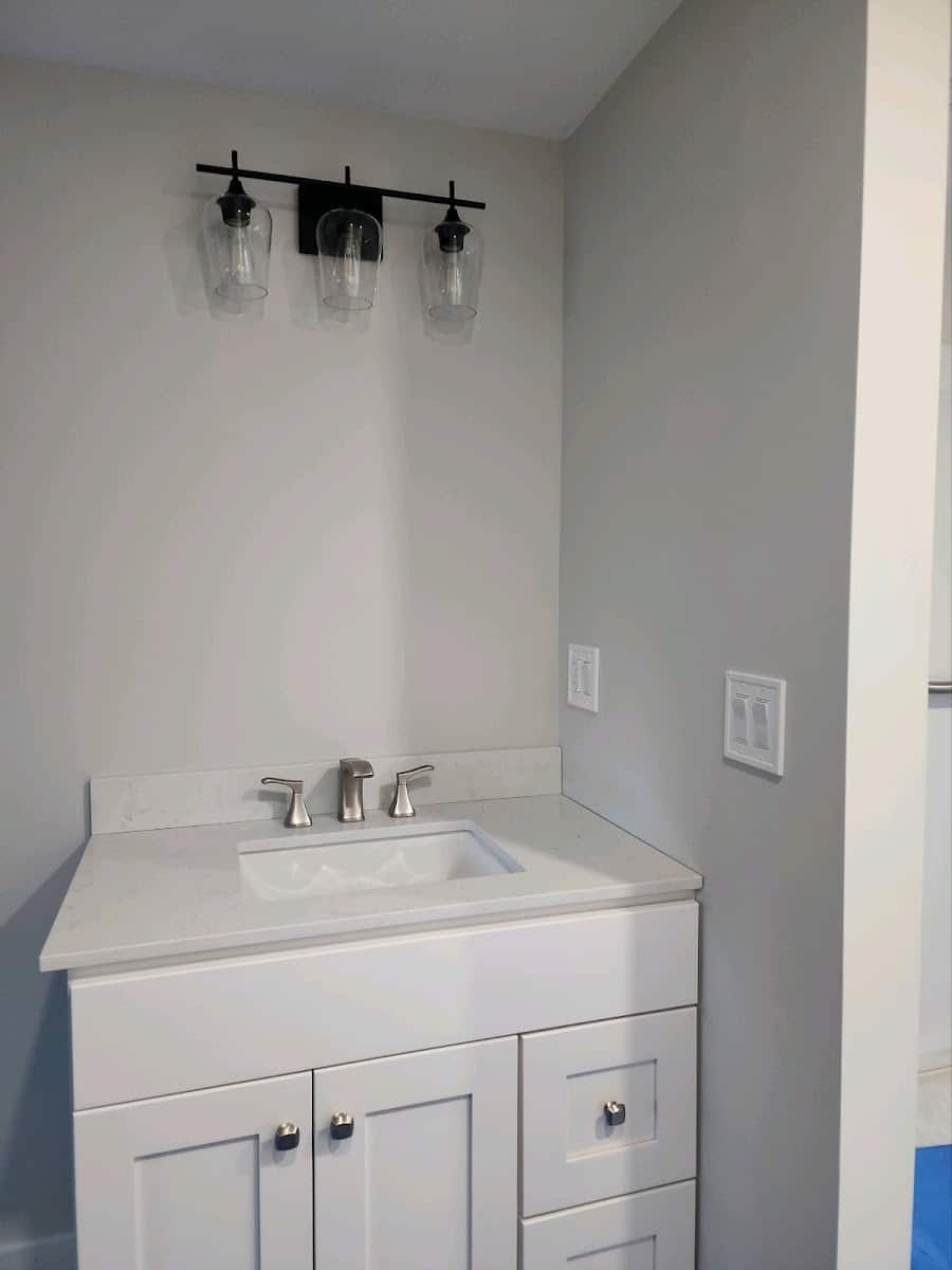 Three-light vanity fixture installed over a bathroom sink